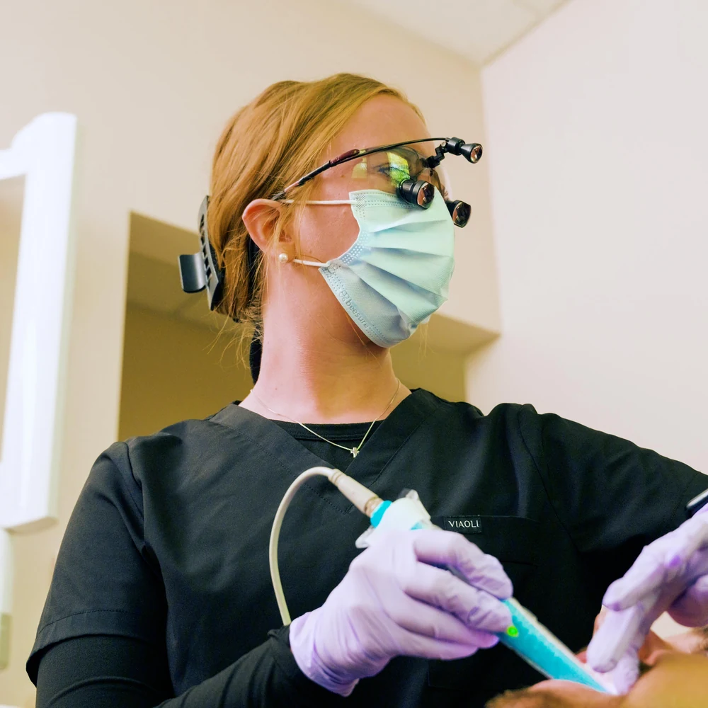 A hygienist cleaning a patient's teeth