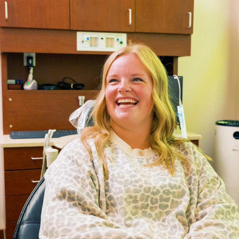 A smiling patient in the treatment chair