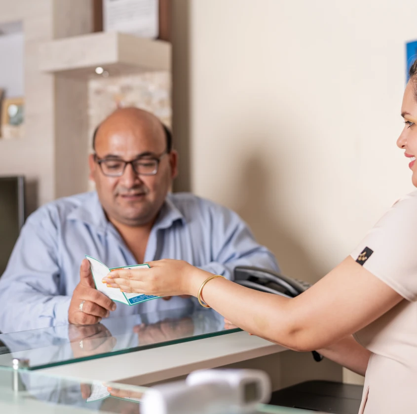 A patient reviewing paperwork handed to him by a team member