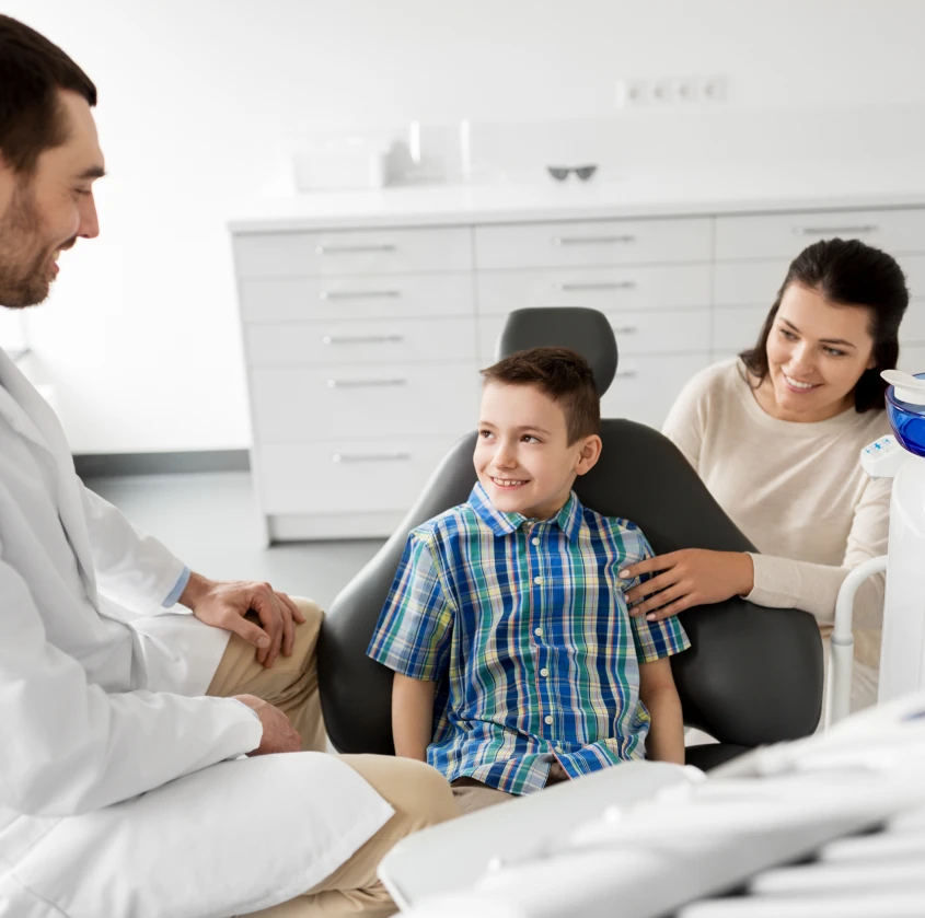 A child at his checkup with his mother and the dentist