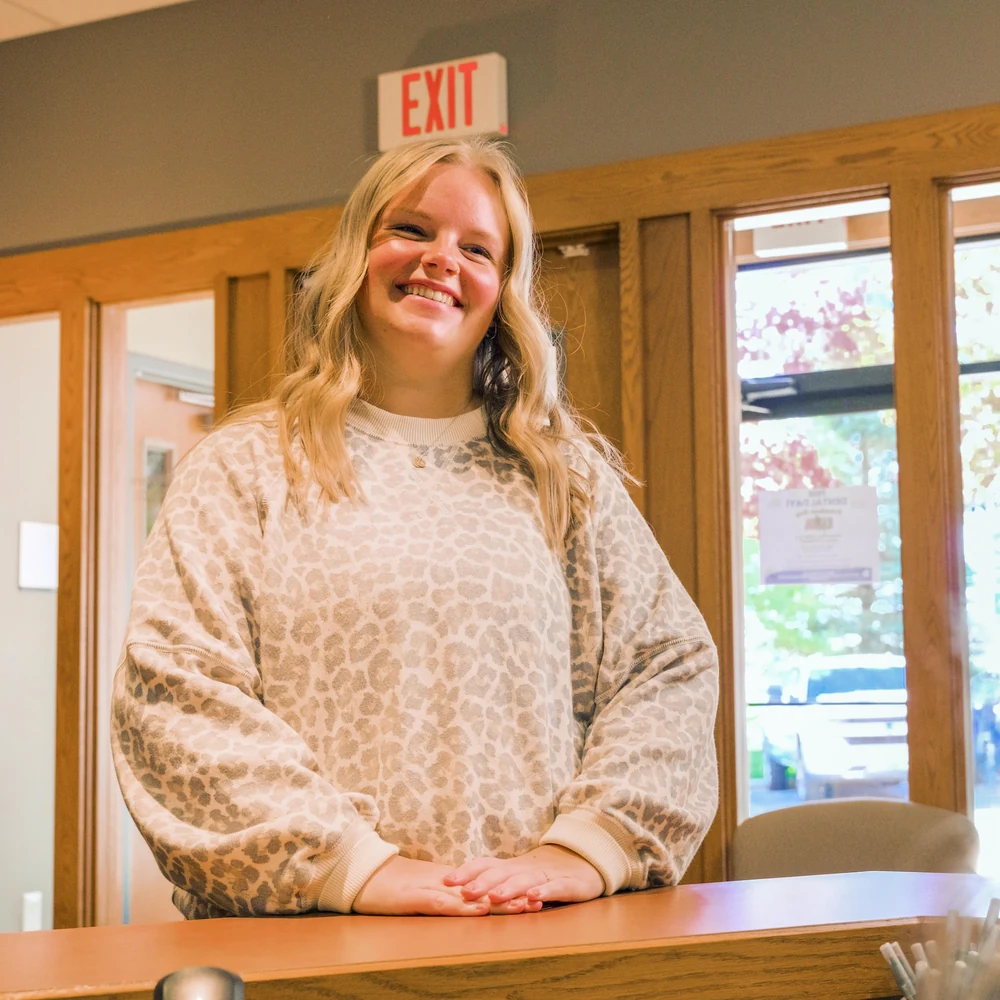 A front-desk team member warmly greeting a patient
