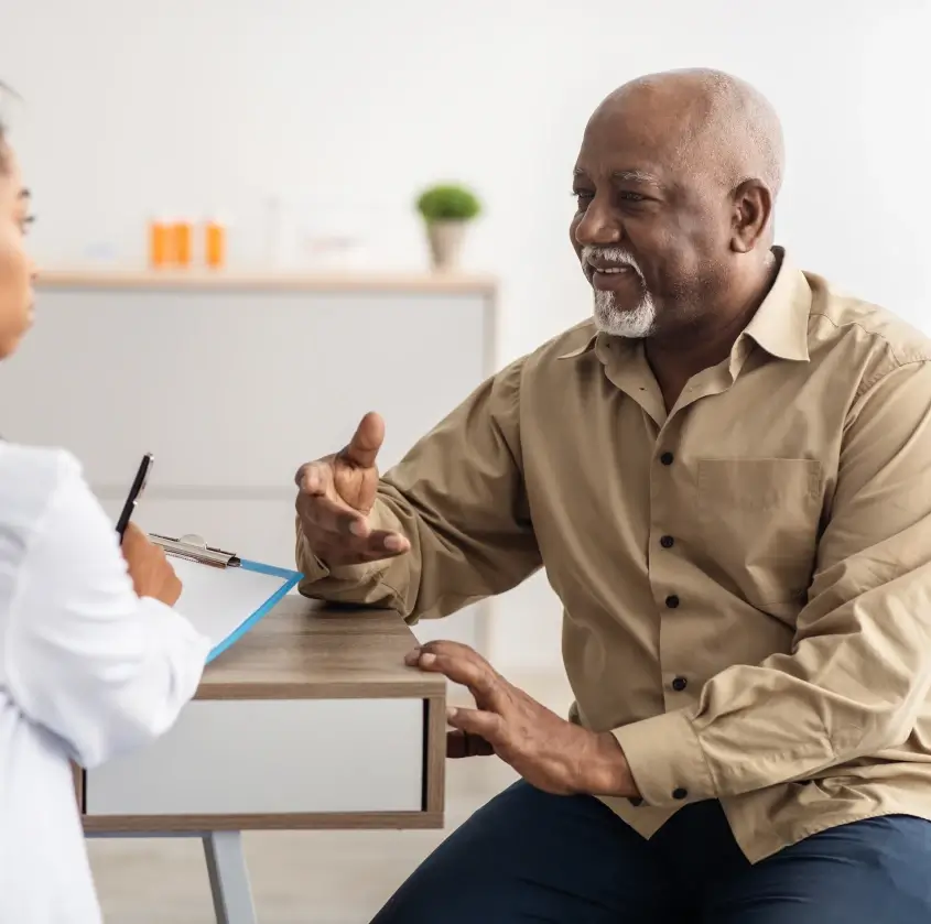A senior patient discussing his treatment plan with the dental team