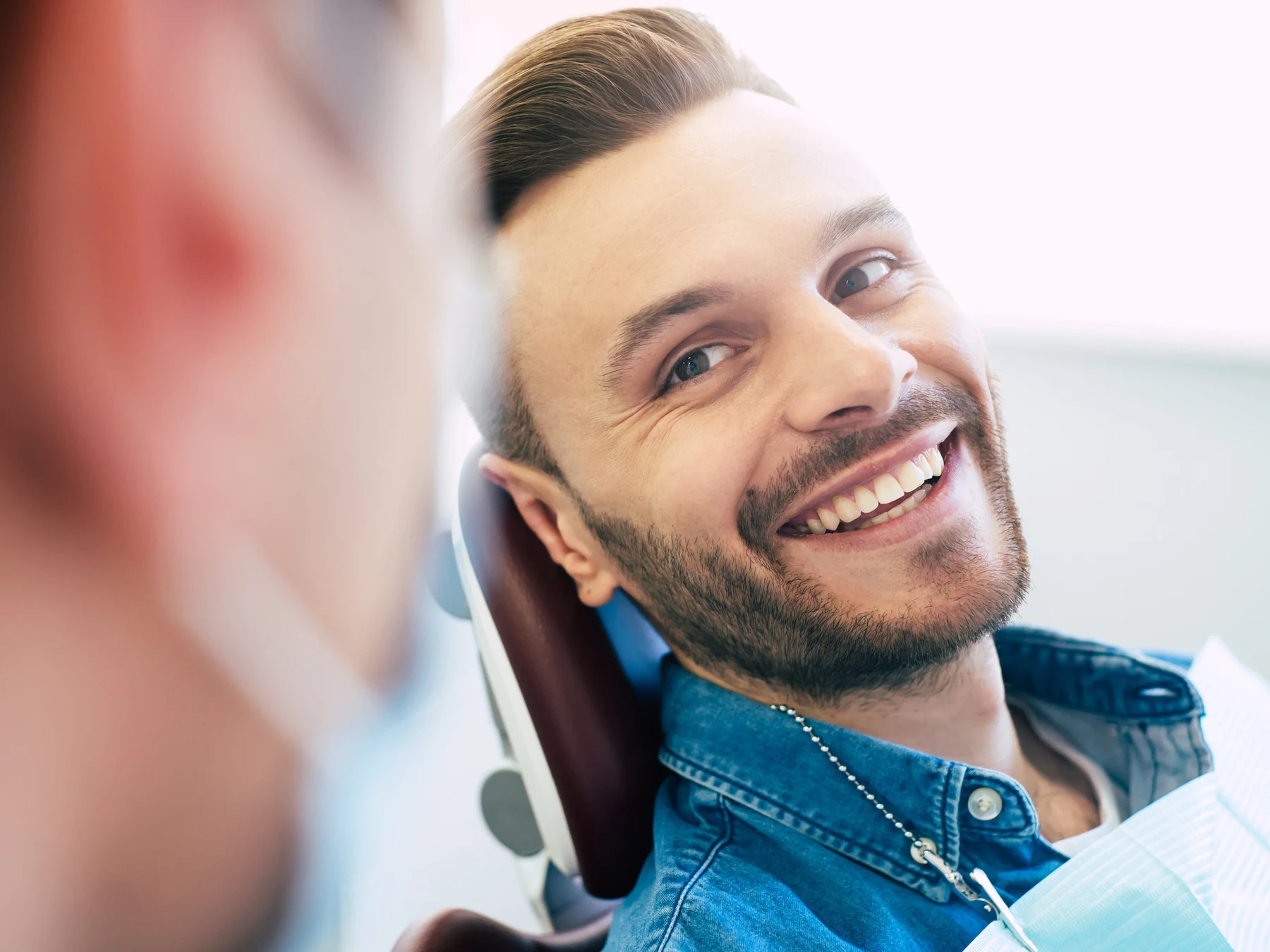 A patient smiling and relaxed in the dental chair during a checkup