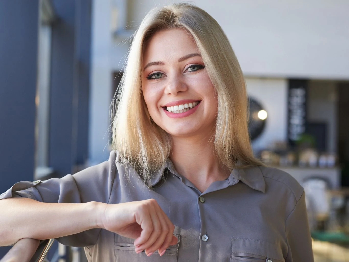 A woman with a bright, white smile outdoors