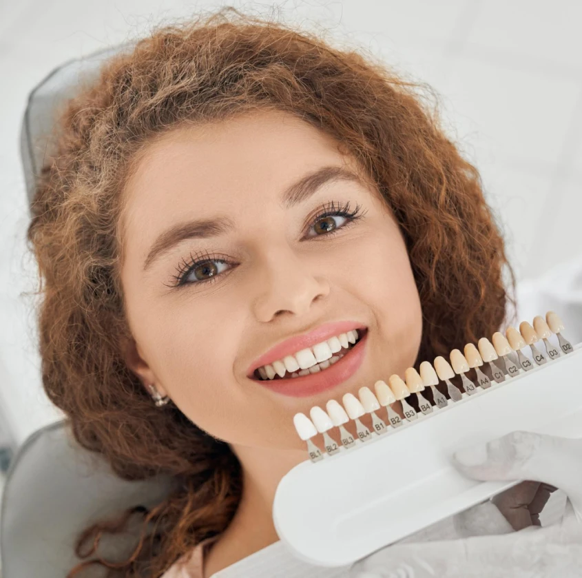 A smiling patient comparing veneer shade options